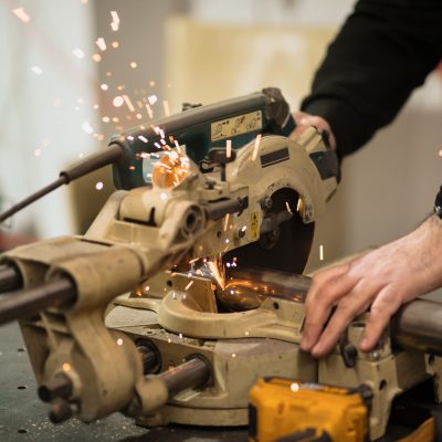 Technician worker cutting metal with many sharp sparks. Using equipments to cat iron